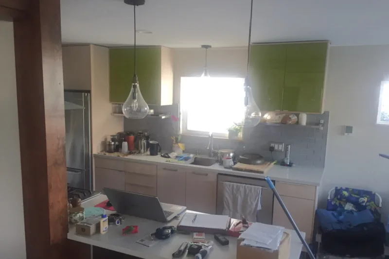 Before view of gray kitchen open to dining