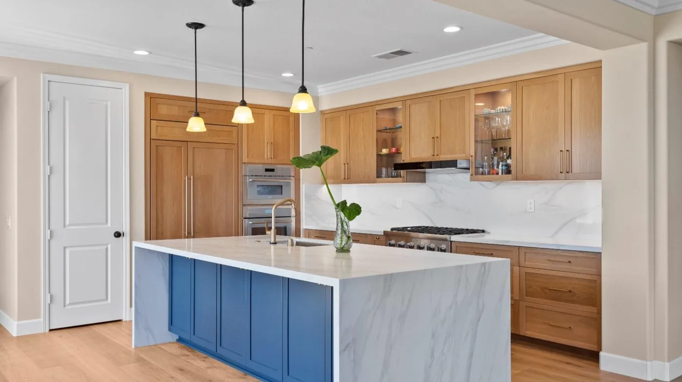 After view of natural wood cabinets with blue island
