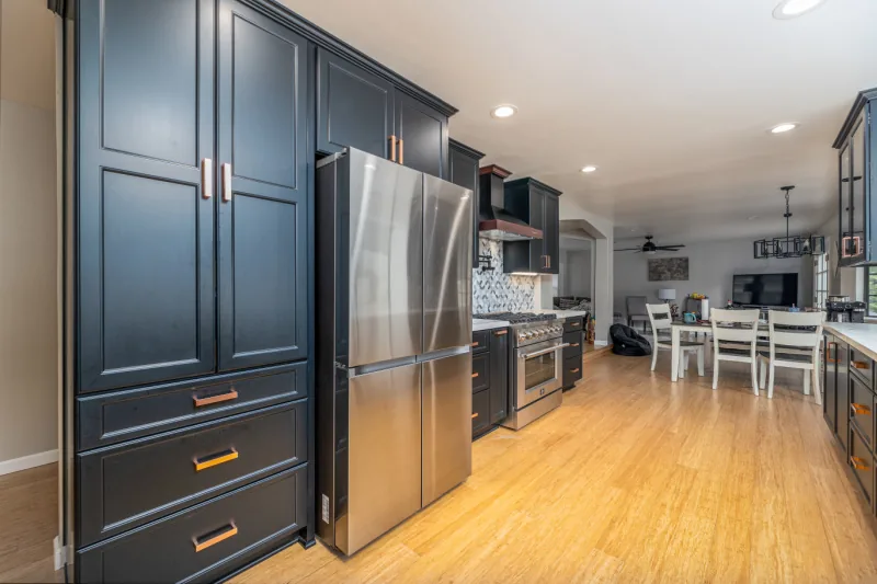 After view of navy cabinets with stainless appliances