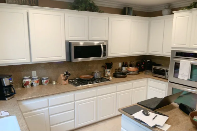 Before view of white kitchen with dark island