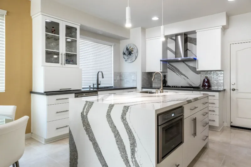 After view of white kitchen with waterfall island