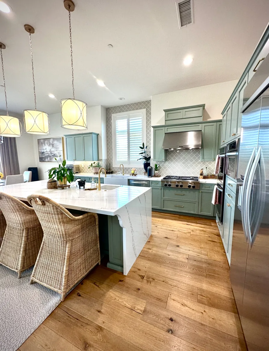 Kitchen after professional cabinet refinishing with soft green cabinets
