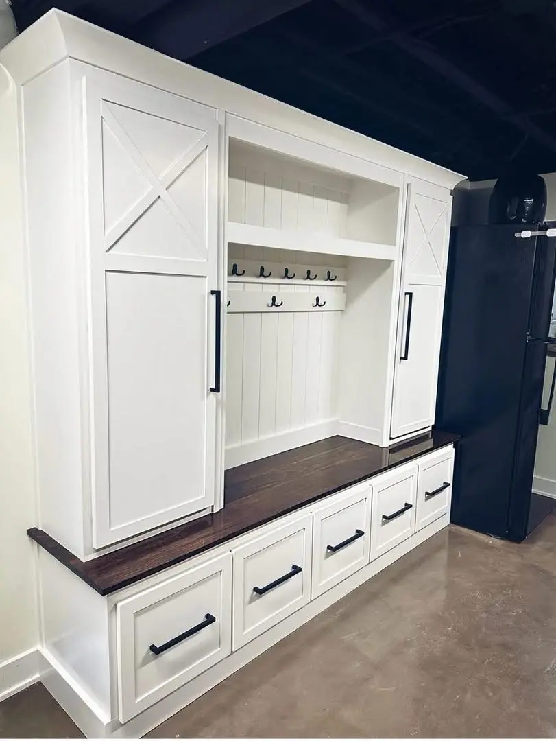 White mudroom lockers with drawers and a wood bench
